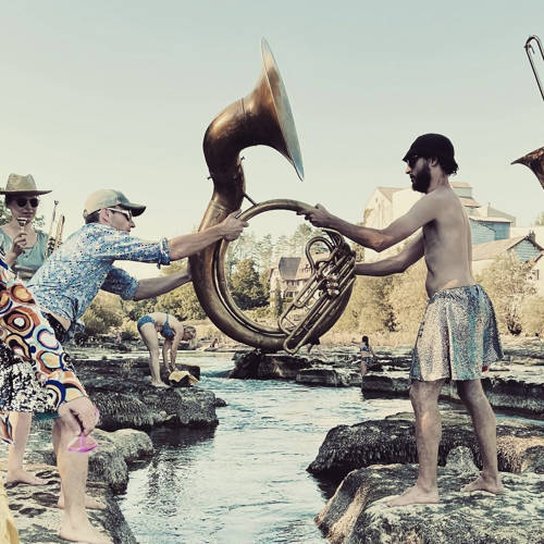 Abel et Nicard passent un soubassophone au-dessus d'une rivière. Crédit Photo : Les Krapos.